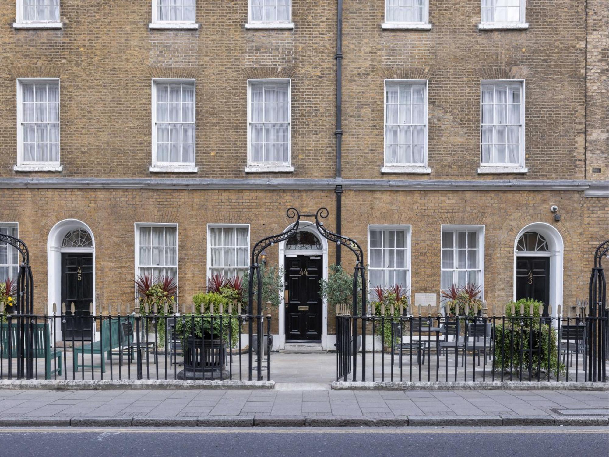 Montcalm Brewery Townhouse Hotel Londen Buitenkant foto The photo shows a row of three-story brick buildings, featuring a classic design with large windows and decorative ironwork. The buildings are painted in a muted yellow-brown color, typical of older urban architecture. In front of the buildings, ther