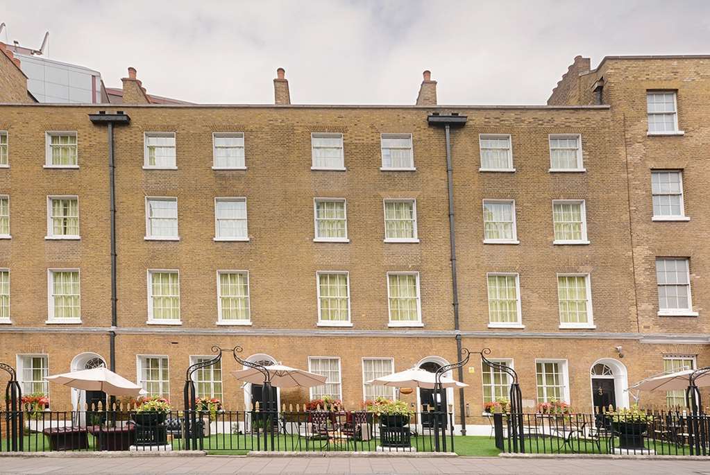 Montcalm Brewery Townhouse Hotel Londen Buitenkant foto The photo shows a brick building with several windows on its facade. The structure appears to be three stories tall, featuring a symmetrical design with multiple windows that have white frames. In front of the building, there is a landscaped area wit