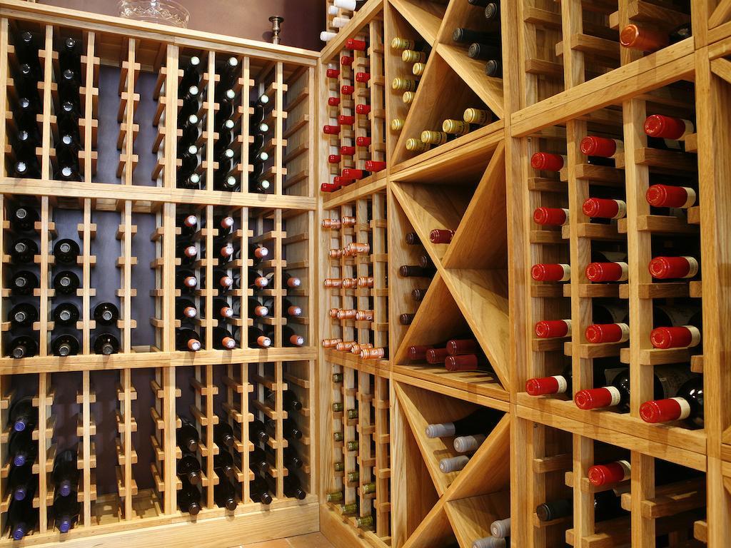Montcalm Brewery Townhouse Hotel Londen Buitenkant foto The photo shows a wine cellar with wooden racks designed for storing wine bottles. The structure is divided into sections, featuring various compartments that hold the bottles in an organized manner. The bottles have different colors, with many red a