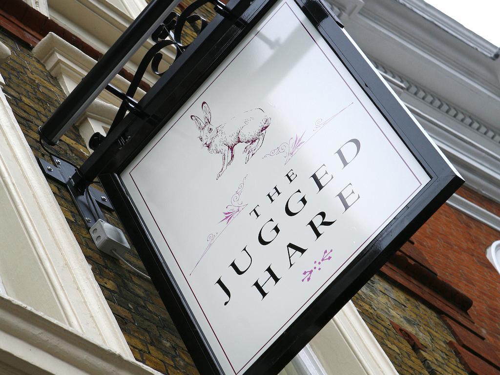 Montcalm Brewery Townhouse Hotel Londen Buitenkant foto The photo shows a hanging sign for a place called "The Jugged Hare." The design features an illustration of a hare, along with the name displayed prominently in bold letters. The overall aesthetic combines an elegant font with delicate floral accents